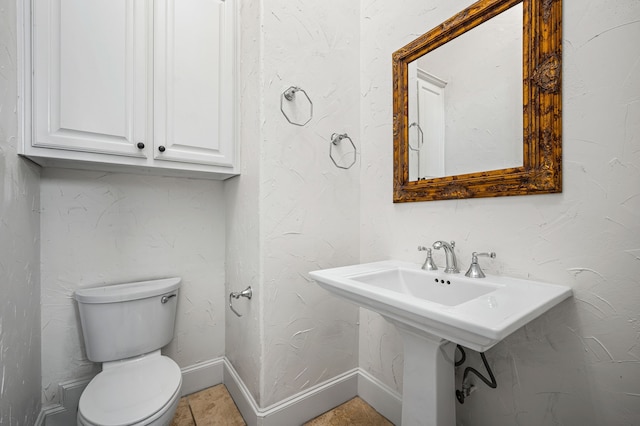 bathroom with baseboards and toilet