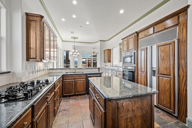 kitchen featuring black appliances, ornamental molding, a sink, stone tile floors, and a center island