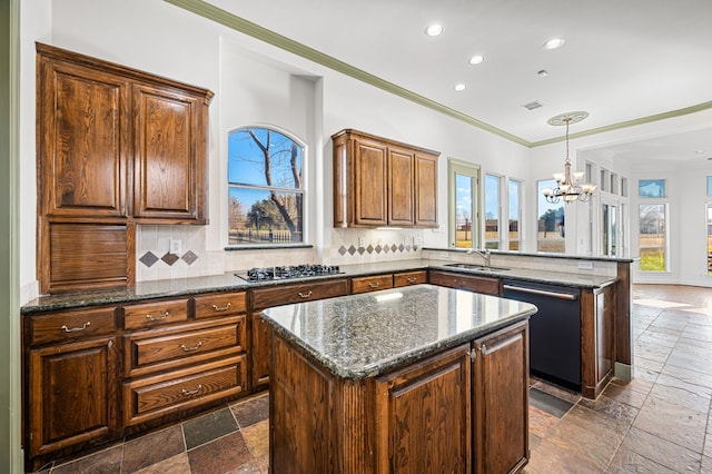 kitchen with gas stovetop, a sink, dishwashing machine, and stone tile flooring