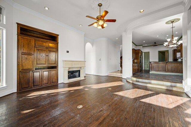 unfurnished living room featuring recessed lighting, a fireplace with raised hearth, dark wood-style flooring, and ceiling fan with notable chandelier