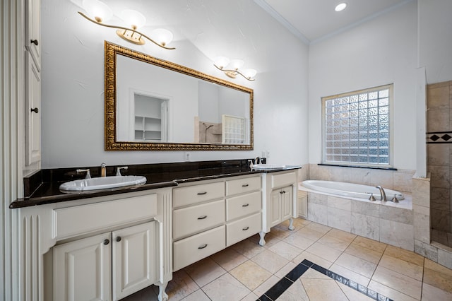 bathroom featuring crown molding, a relaxing tiled tub, vanity, and tile patterned floors