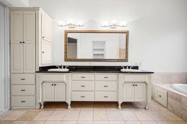 bathroom featuring double vanity, a relaxing tiled tub, and a sink