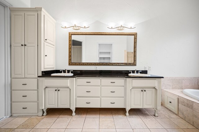 full bathroom featuring double vanity, a sink, and a relaxing tiled tub
