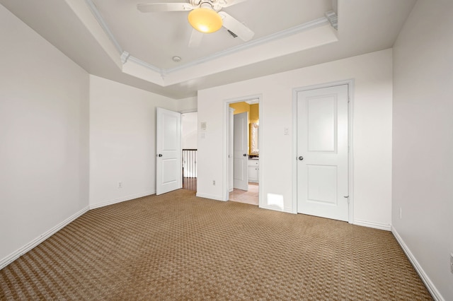 unfurnished bedroom with a raised ceiling, ornamental molding, baseboards, and light carpet