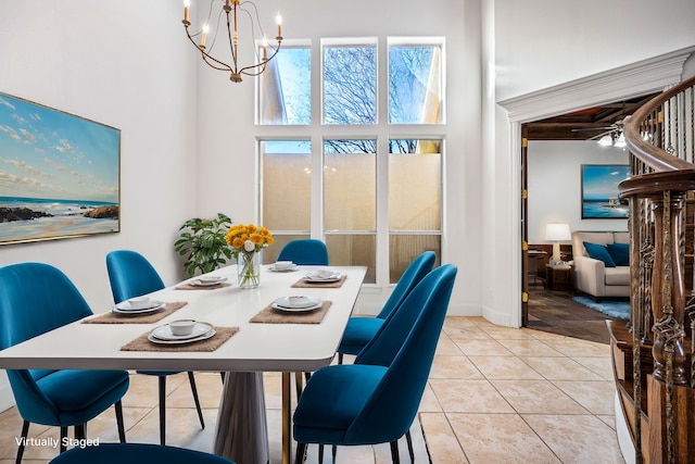 dining room featuring light tile patterned floors, a chandelier, baseboards, and a towering ceiling