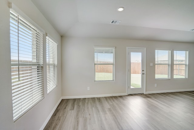 empty room with lofted ceiling and light wood-type flooring