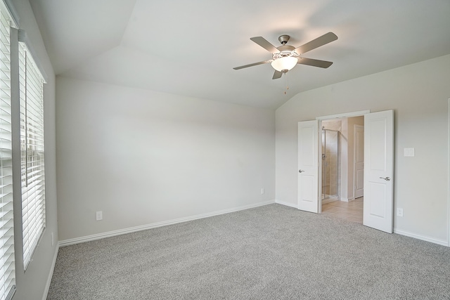 carpeted spare room with vaulted ceiling and ceiling fan