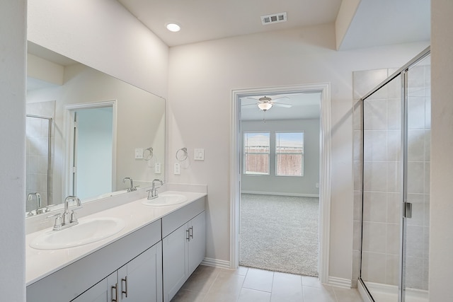 bathroom featuring tile patterned floors, ceiling fan, a shower with door, and vanity