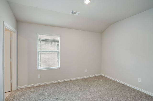 empty room featuring light colored carpet and lofted ceiling