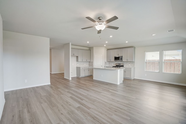 unfurnished living room featuring ceiling fan, sink, and light hardwood / wood-style flooring