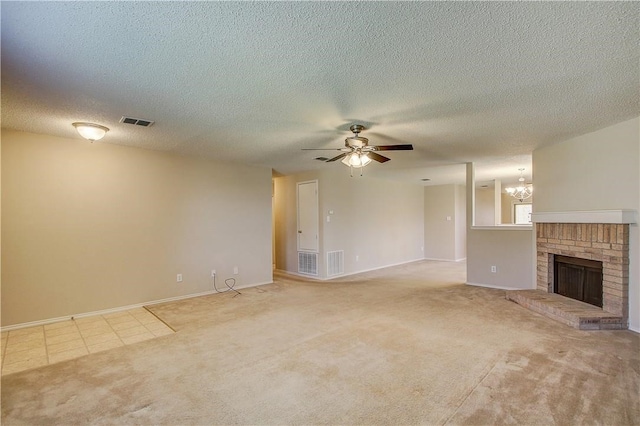 unfurnished living room with a fireplace, a textured ceiling, ceiling fan with notable chandelier, and light colored carpet