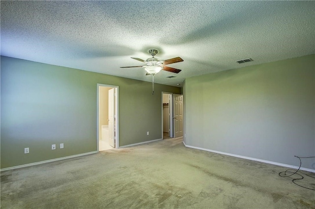 empty room featuring ceiling fan, light colored carpet, and a textured ceiling