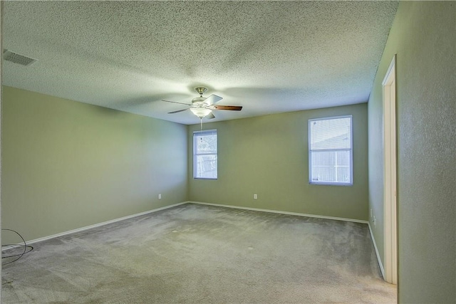 spare room with ceiling fan, light colored carpet, and a textured ceiling