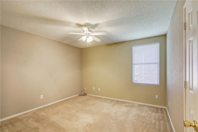 spare room with ceiling fan, light colored carpet, and a textured ceiling