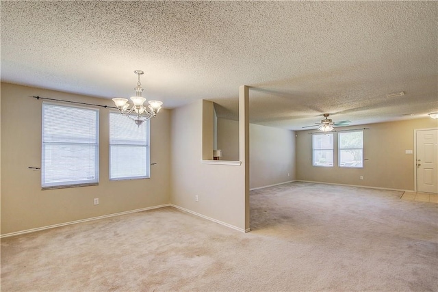 carpeted spare room with a textured ceiling and ceiling fan with notable chandelier