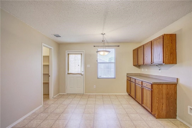 kitchen with hanging light fixtures and a textured ceiling