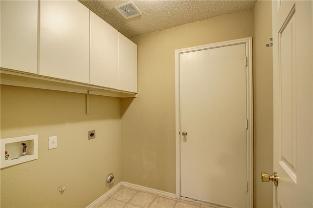 laundry area featuring hookup for a washing machine, cabinets, a textured ceiling, and hookup for an electric dryer