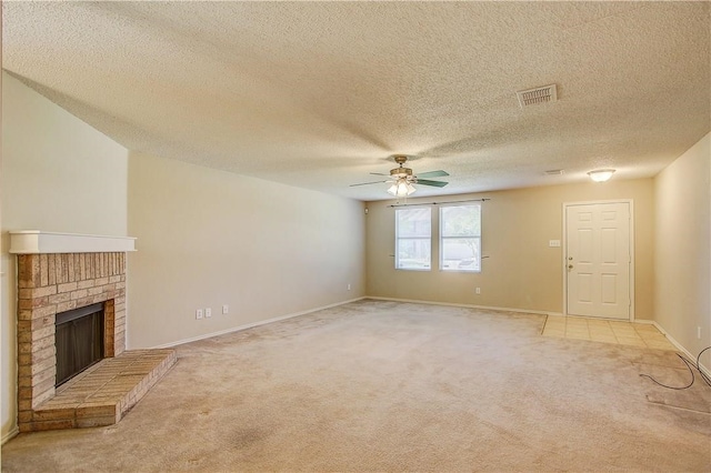 unfurnished living room featuring a textured ceiling, ceiling fan, light colored carpet, and a fireplace