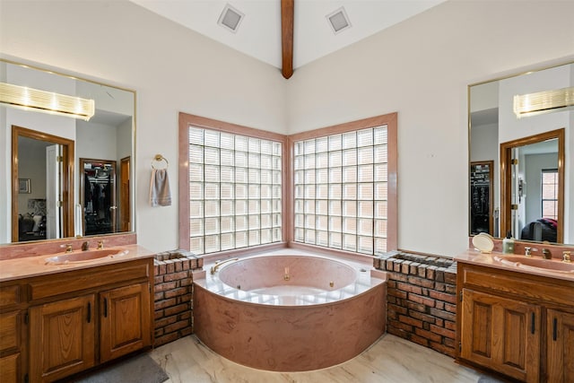 bathroom with vanity, vaulted ceiling with beams, and a tub to relax in