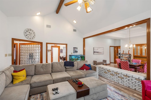 living room with wood-type flooring, ceiling fan with notable chandelier, beamed ceiling, and high vaulted ceiling