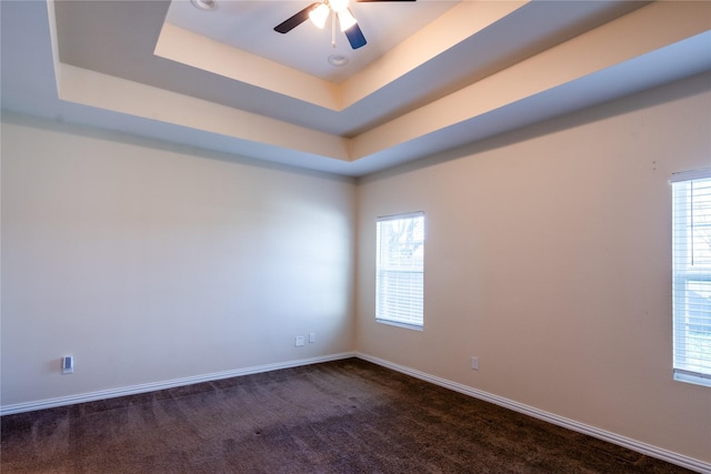 carpeted empty room featuring ceiling fan and a tray ceiling