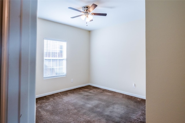 spare room featuring ceiling fan and dark carpet