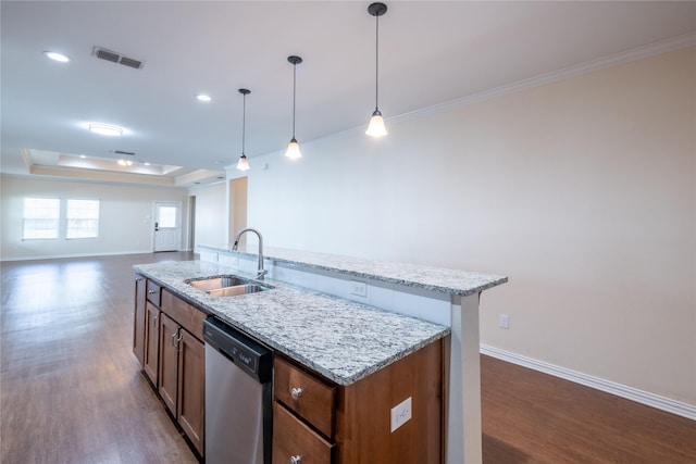 kitchen with stainless steel dishwasher, sink, a tray ceiling, hanging light fixtures, and an island with sink