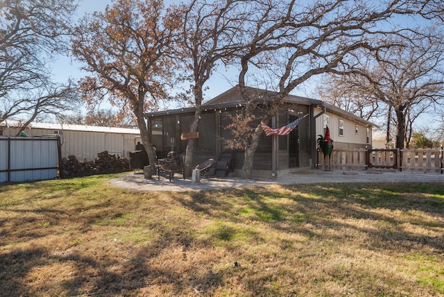 rear view of house featuring a lawn and a patio