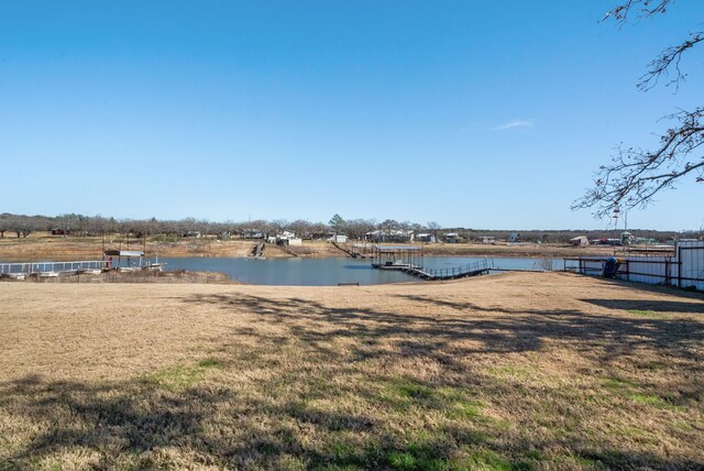 dock area with a yard and a water view