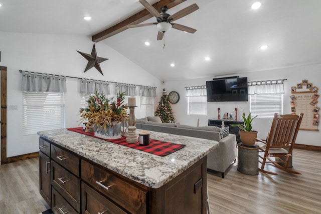 kitchen featuring a center island, lofted ceiling with beams, light hardwood / wood-style flooring, ceiling fan, and dark brown cabinetry