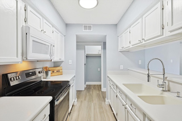 kitchen featuring white cabinetry, sink, stainless steel range with electric stovetop, and light hardwood / wood-style flooring