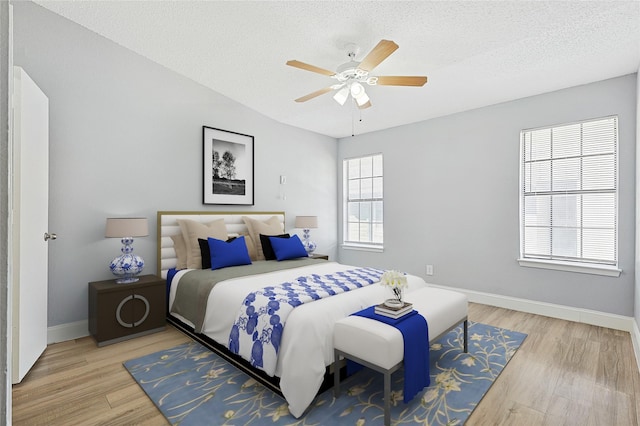 bedroom featuring a textured ceiling, light hardwood / wood-style floors, and ceiling fan