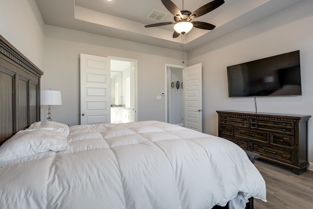 bedroom featuring ceiling fan, a tray ceiling, and hardwood / wood-style floors