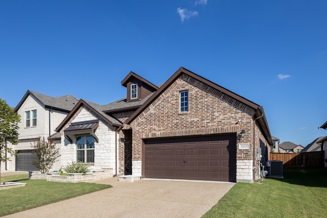 view of front of property featuring a front lawn, central AC unit, and a garage