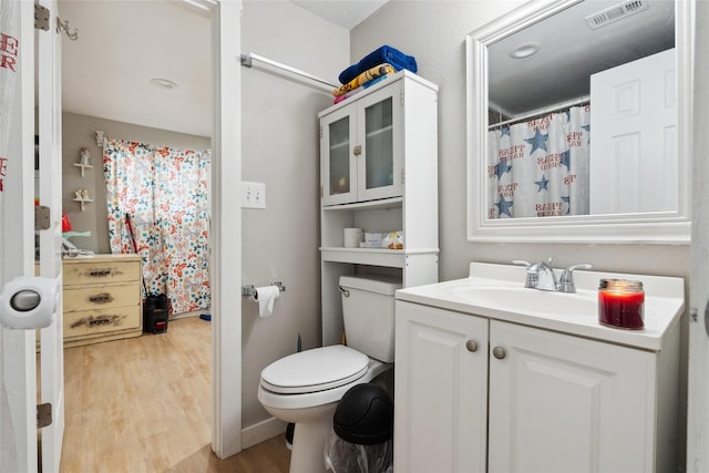 bathroom featuring toilet, vanity, and hardwood / wood-style flooring