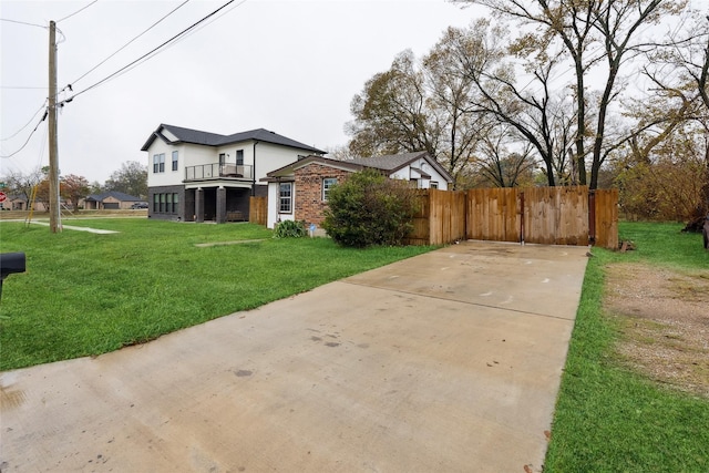 view of front facade featuring a front yard and a balcony