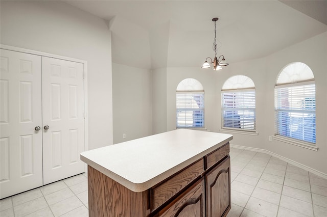 kitchen with a chandelier, light tile patterned floors, a center island, and hanging light fixtures