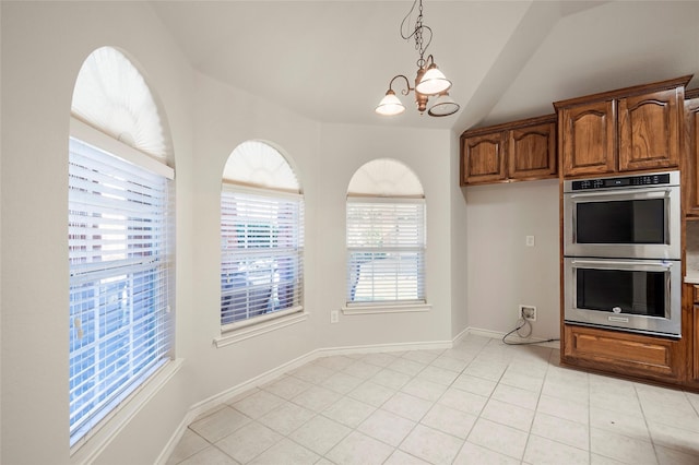 kitchen featuring stainless steel double oven, light tile patterned floors, decorative light fixtures, a chandelier, and lofted ceiling