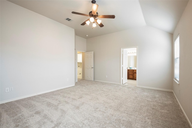 unfurnished bedroom featuring ensuite bathroom, ceiling fan, light colored carpet, and vaulted ceiling