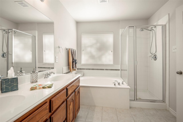 bathroom featuring plus walk in shower, vanity, and tile patterned floors