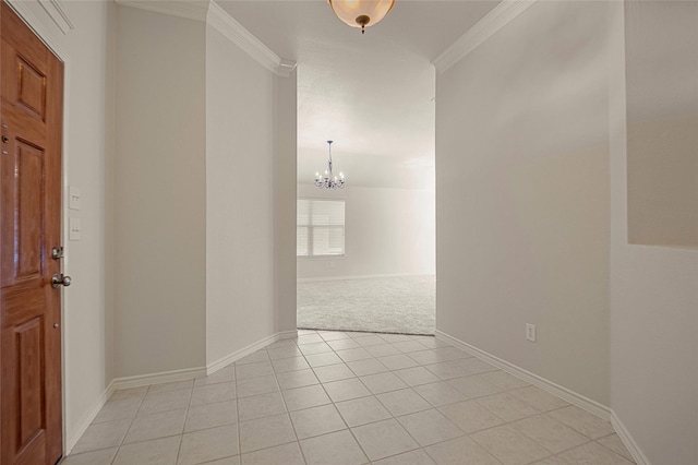 tiled entrance foyer with ornamental molding and a notable chandelier