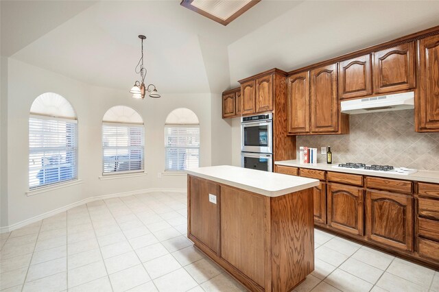 kitchen featuring stainless steel double oven, white gas cooktop, pendant lighting, decorative backsplash, and a kitchen island