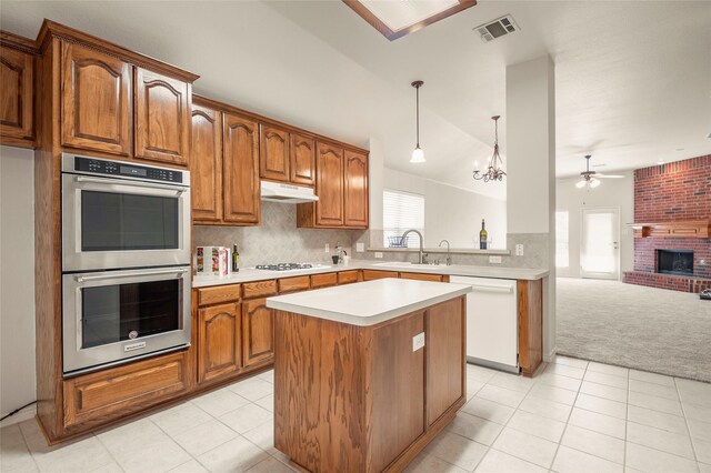 kitchen featuring dishwasher, double oven, kitchen peninsula, pendant lighting, and vaulted ceiling