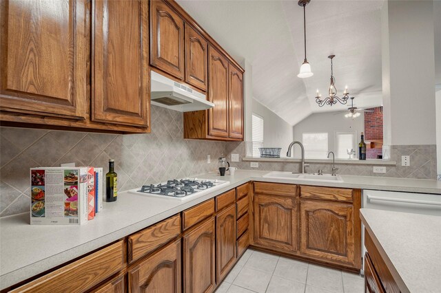 kitchen featuring white gas cooktop, ceiling fan with notable chandelier, sink, hanging light fixtures, and vaulted ceiling