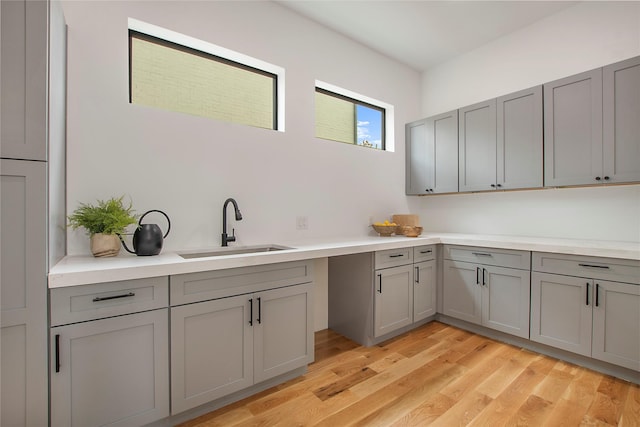 kitchen featuring gray cabinets, light hardwood / wood-style floors, and sink