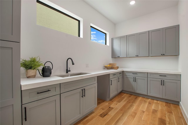 kitchen featuring light hardwood / wood-style flooring, gray cabinetry, and sink