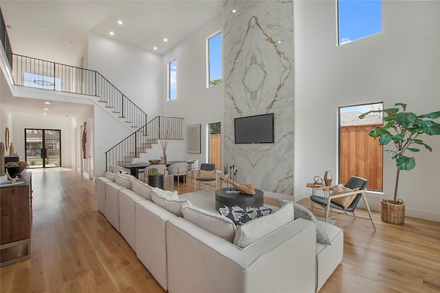 living room featuring a high ceiling and light hardwood / wood-style floors