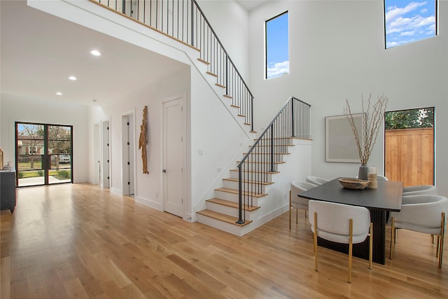 stairs with a high ceiling and hardwood / wood-style flooring