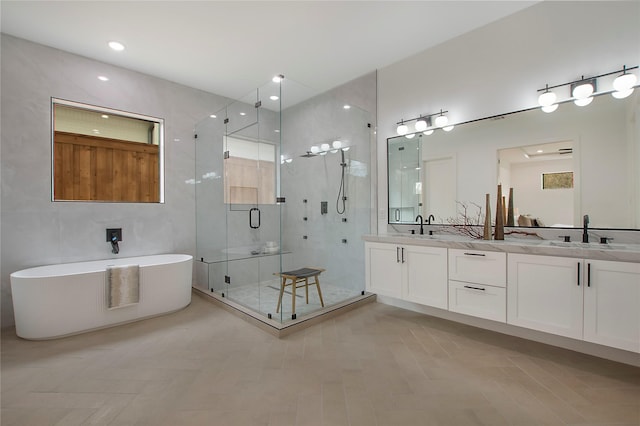 bathroom with vanity and shower with separate bathtub