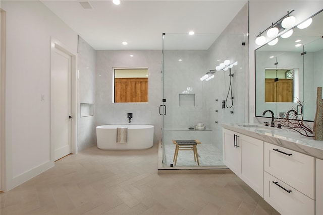 bathroom featuring vanity and independent shower and bath